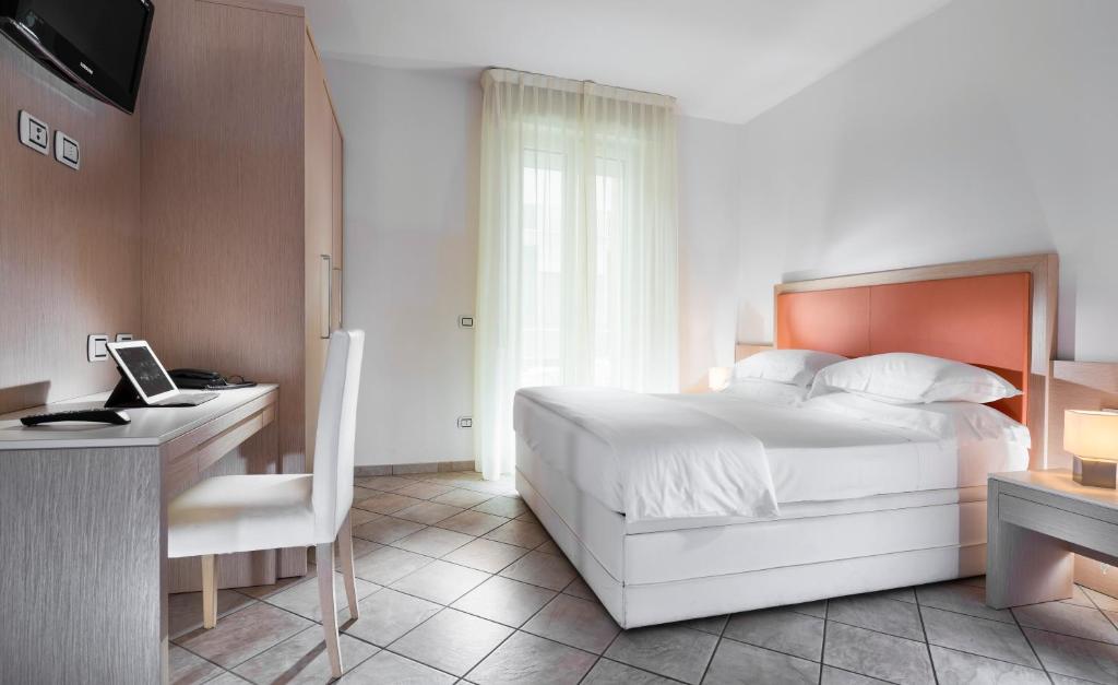 sypialnia z łóżkiem i biurkiem z laptopem w obiekcie Milano Family Suite w mieście Bellaria-Igea Marina