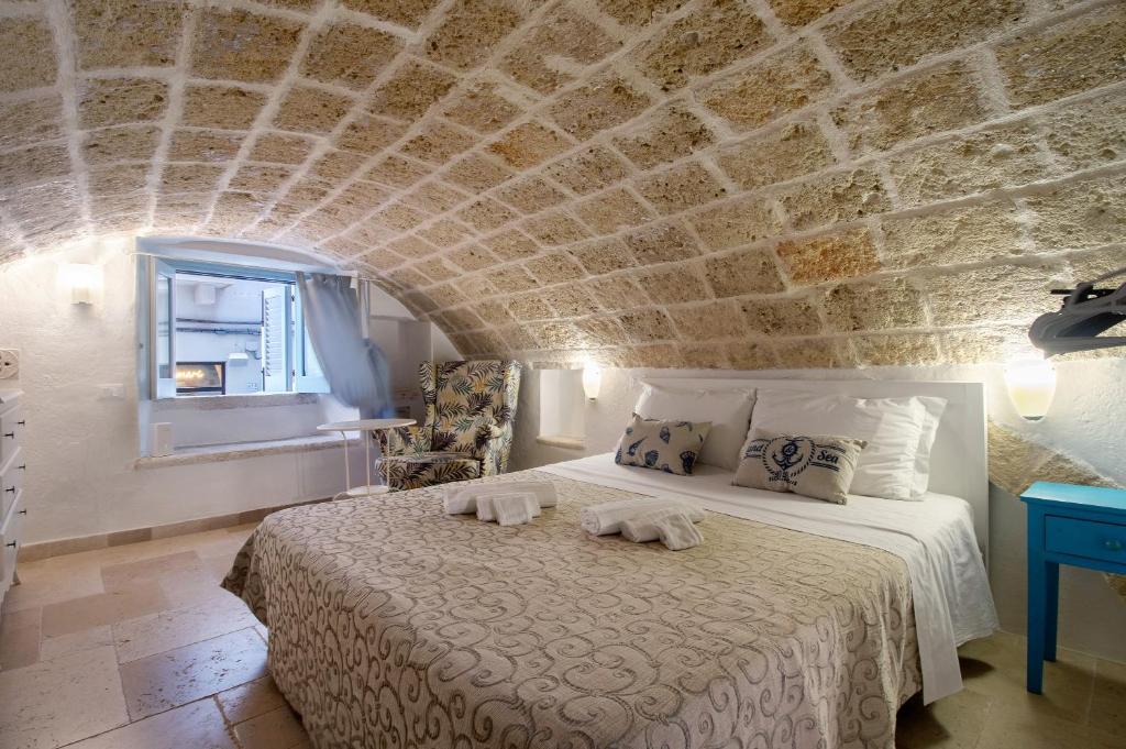 a bedroom with a bed with a stone wall at Il Pescatore in Monopoli
