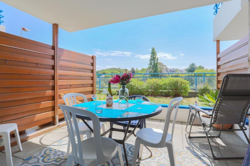 a patio with a blue table and chairs on a balcony at T2 avec terrasse proche plages in Pléneuf-Val-André