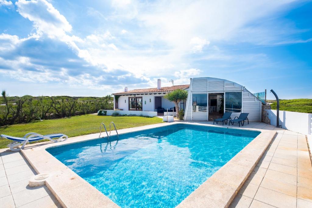 a villa with a swimming pool and a house at Villa Solivent in Es Mercadal
