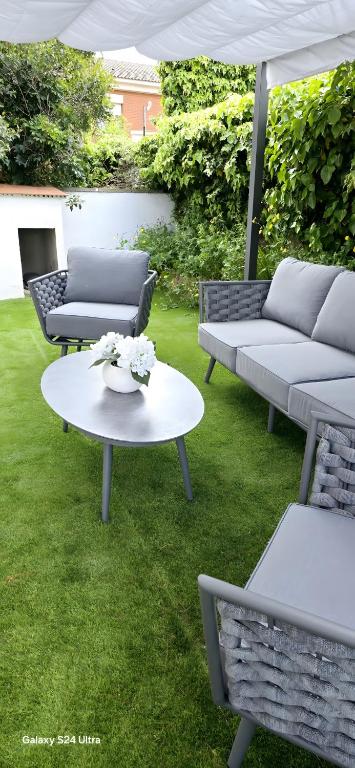 a patio with couches and a table with flowers on it at Casa con mucha luz natural in Bisbal del Penedès