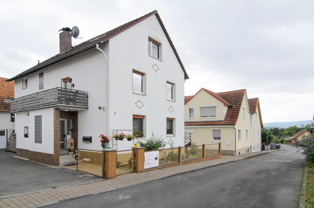 a white house with a wooden fence at Ferienwohnung Storchenblick in Grebendorf
