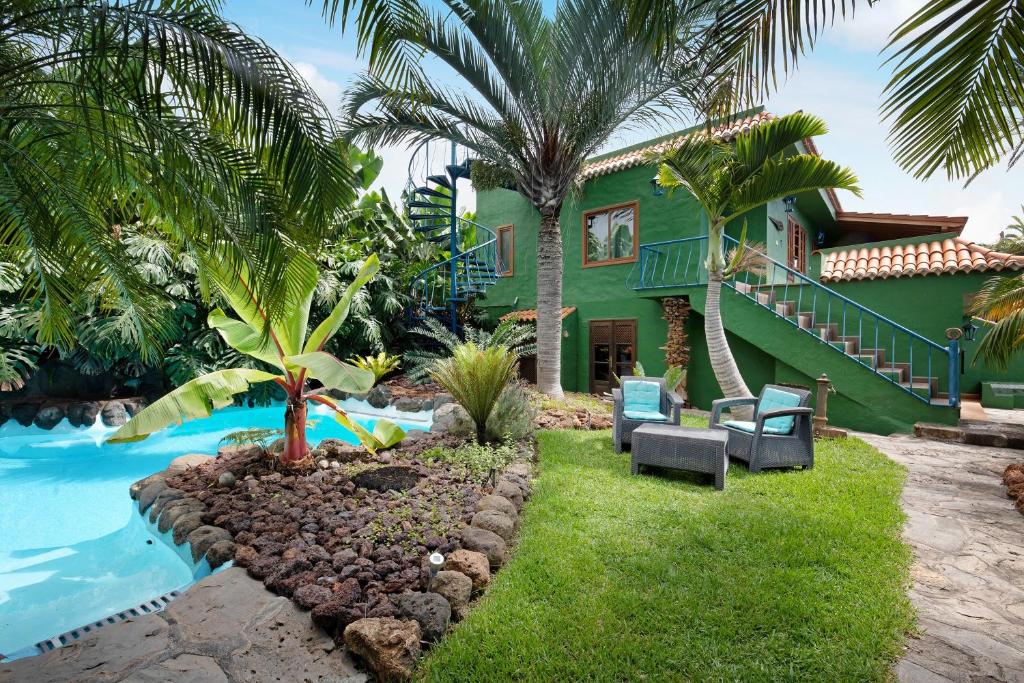 a green house with a swimming pool next to a house at Casa Garten in Tijarafe