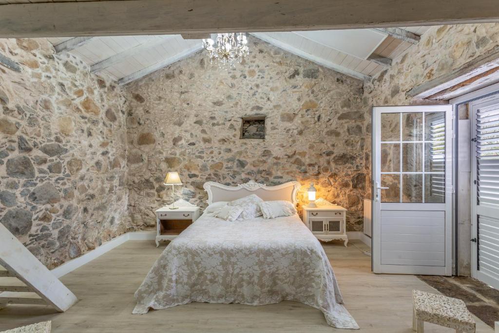 a bedroom with a bed and a stone wall at Toscana Di Corvo in Moya
