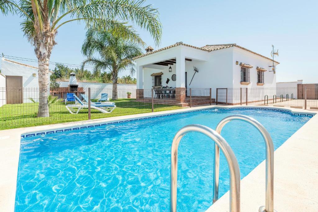 a swimming pool in front of a house at Villa Conilsur in Conil de la Frontera