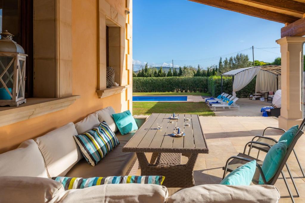 eine Terrasse mit Sofa, Tisch und Stühlen in der Unterkunft Finca Llum in Islas Baleares