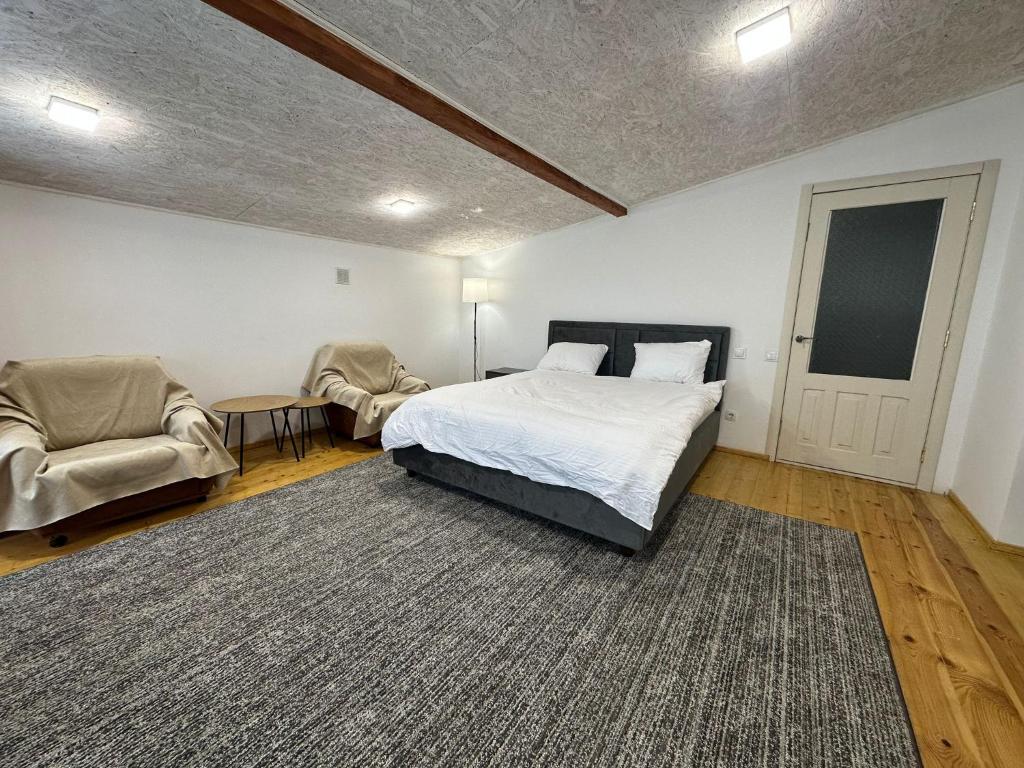 a bedroom with a bed and two chairs at HomeRent Bucuresti Studio in Chişinău