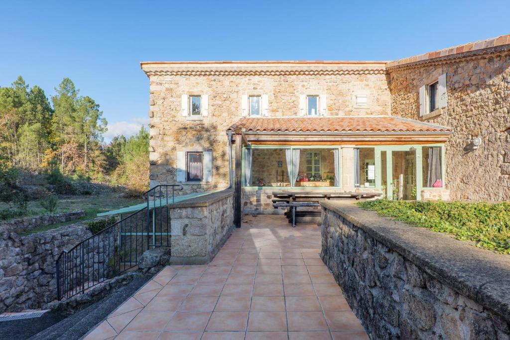 an external view of a stone house with a patio at Perles De Aime in Laurac-en-Vivarais