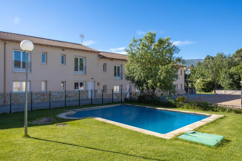 a villa with a swimming pool in front of a house at Las Gargantas de Gredos in Burgohondo