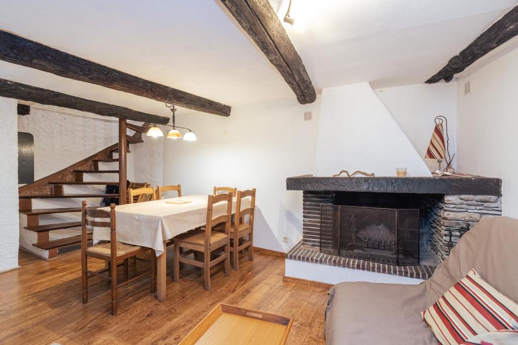 a dining room with a table and a fireplace at Au Petit Paris, Centre de Céret in Céret