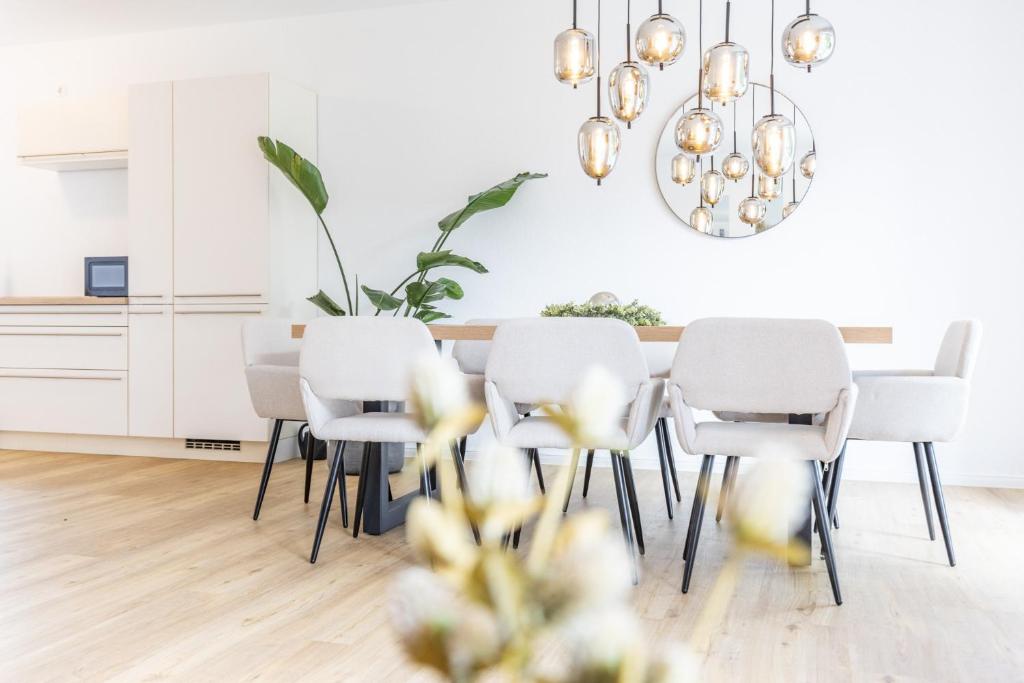 a white dining room with a table and chairs at Das Strandhaus 2 in Lembruch