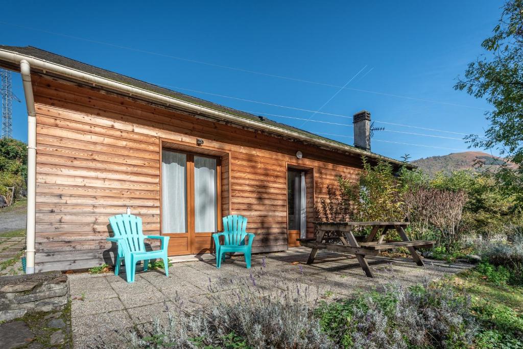 two chairs and a picnic table outside of a cabin at Chalets De L'arriutort 1 - Laruns in Laruns