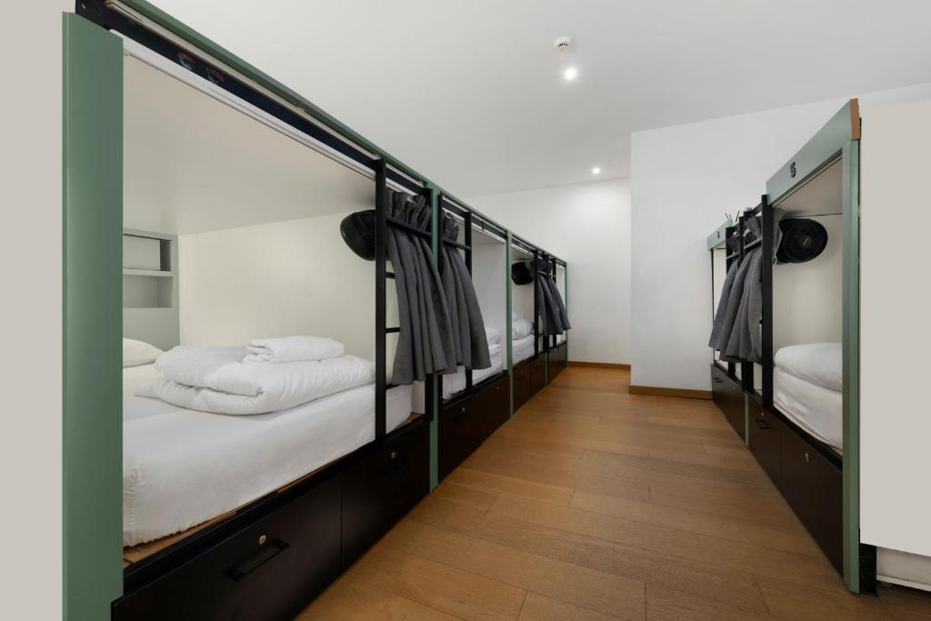 a hallway with four bunk beds in a room at Urban Habitat Capsule Beds in Nicosia