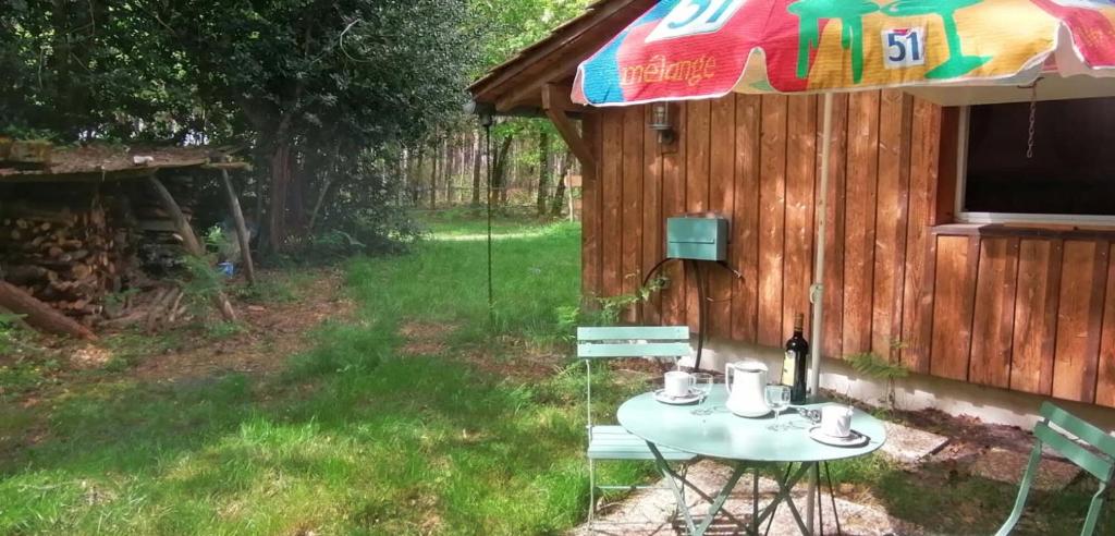un tavolo davanti a un edificio con un ombrellone di La palombière a Saint-Symphorien