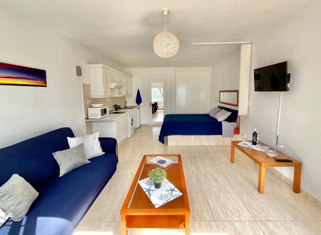 a living room with a blue couch and a table at Atlantic Ocean Rest in Tacoronte