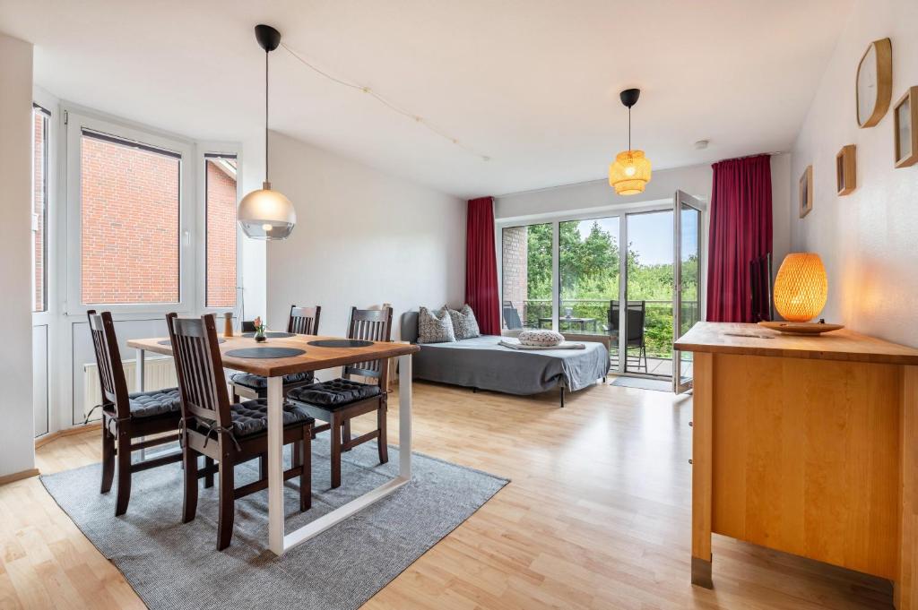 a dining room and living room with a table and chairs at Sonne, Wind und Wetter in Wurster Nordseeküste