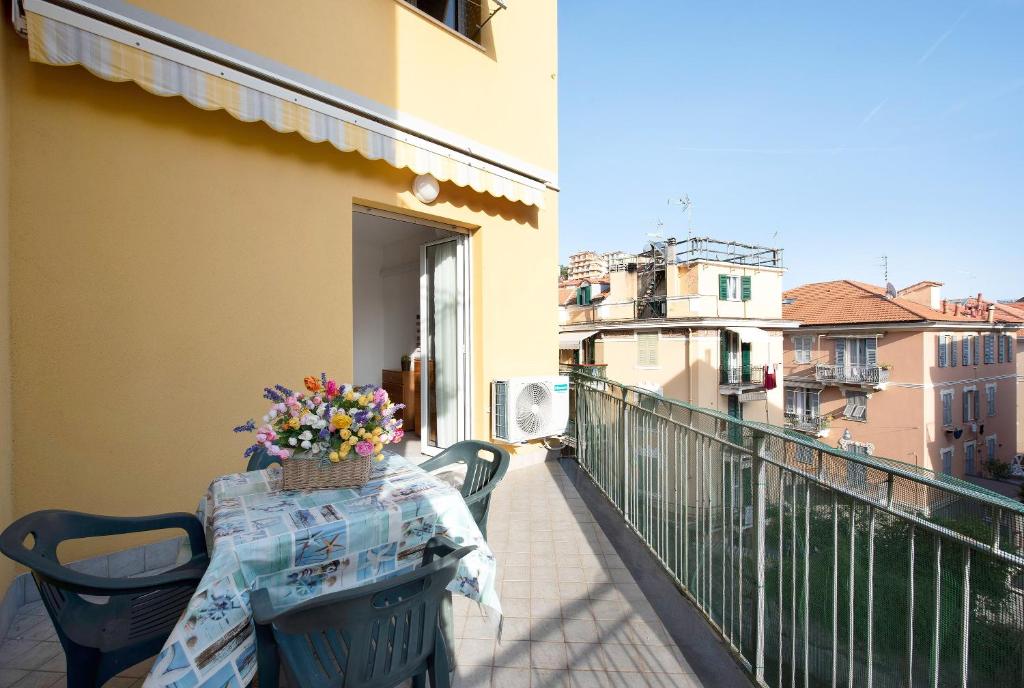 a table with a basket of flowers on a balcony at Trilocale Mazzini con 2 balconi in Varazze
