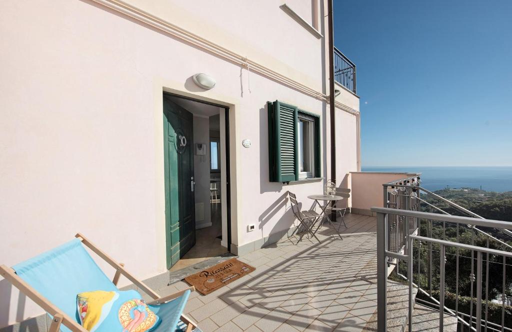 a balcony with a green door and a table and chairs at Casa Marincanto in Varazze