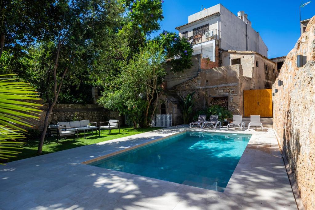 a swimming pool in the backyard of a house with a building at Ca la Senyora dels Arbres in Artá