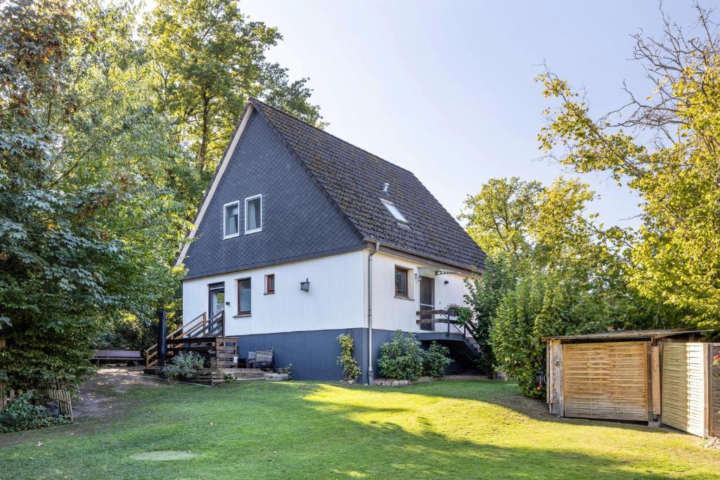 a white house with a black roof and a yard at Gästehaus Oehm in Faßberg