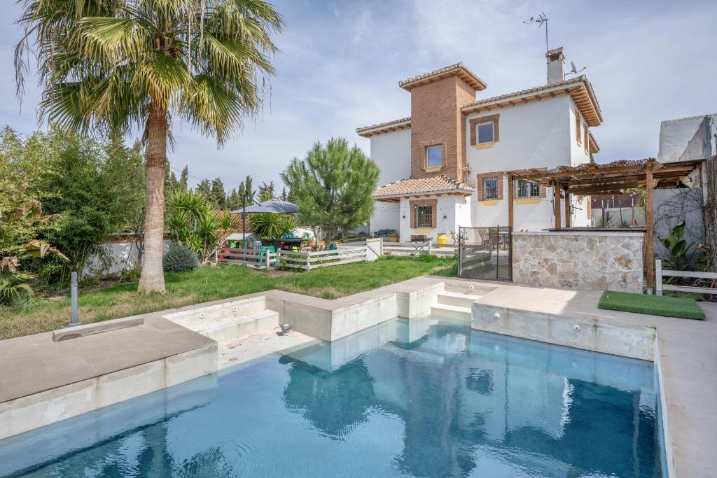 a swimming pool in front of a house at Villavillanos in Otura