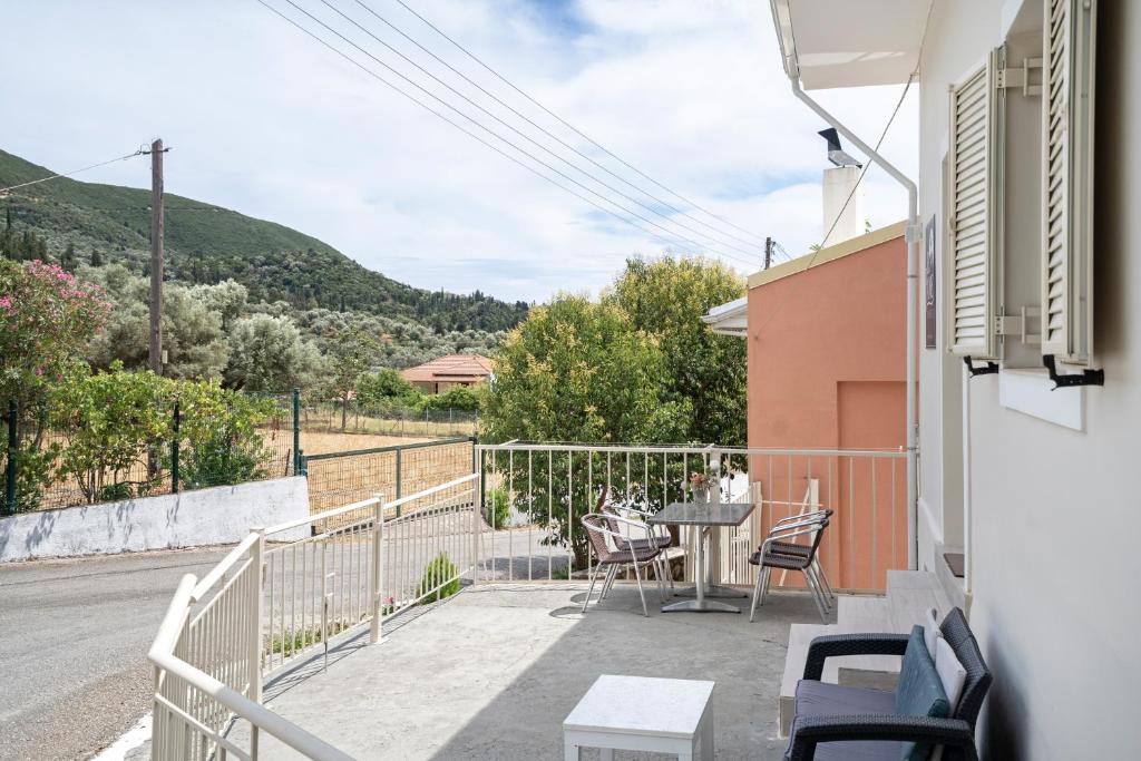 a balcony with a table and chairs and a street at El Padre Residence in Sívros