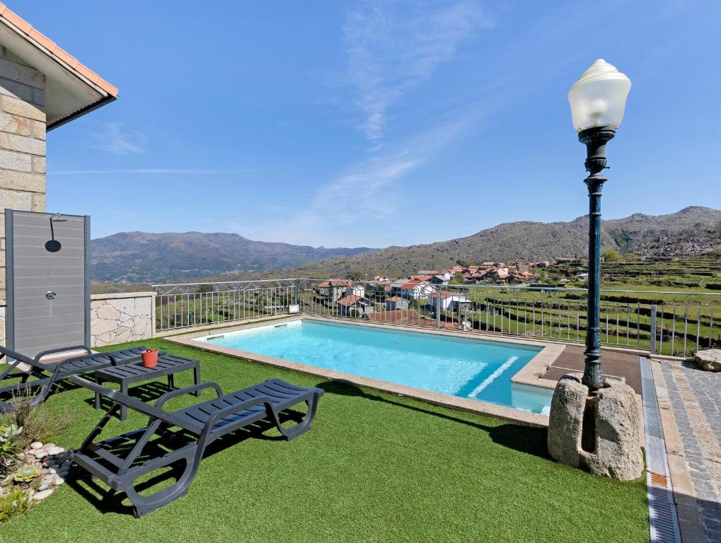 a swimming pool with a table and a light pole at Casa Dona Florinda in Ermida