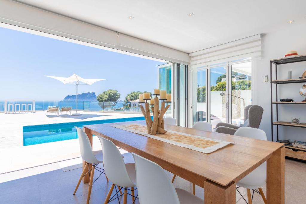 a dining room with a table and a large window at Casa Viviana in Moraira