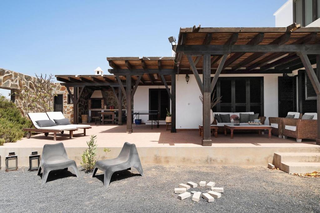 a patio with chairs and a wooden pergola at Casa Jess in Tías