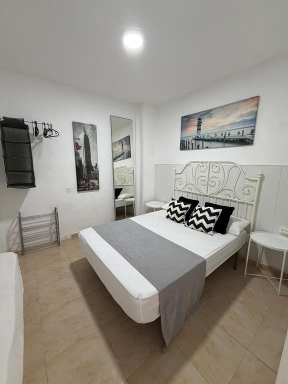 a bedroom with a large bed and some pictures on the wall at apartamento el camarote in Fasnia