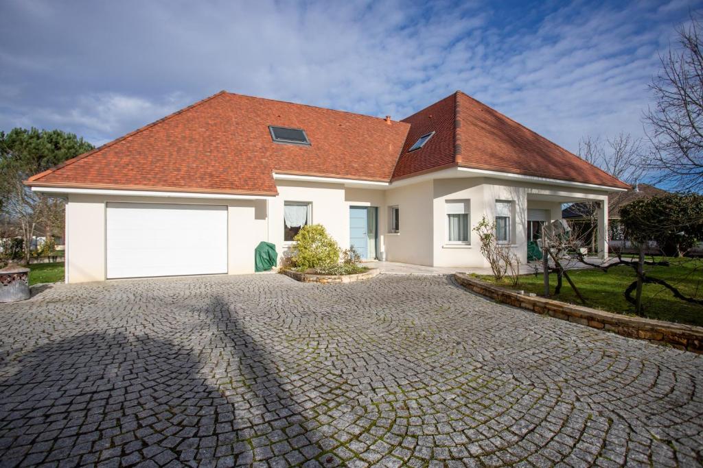 a white house with a red roof and a driveway at Chambre d'hotes à Laroin in Laroin