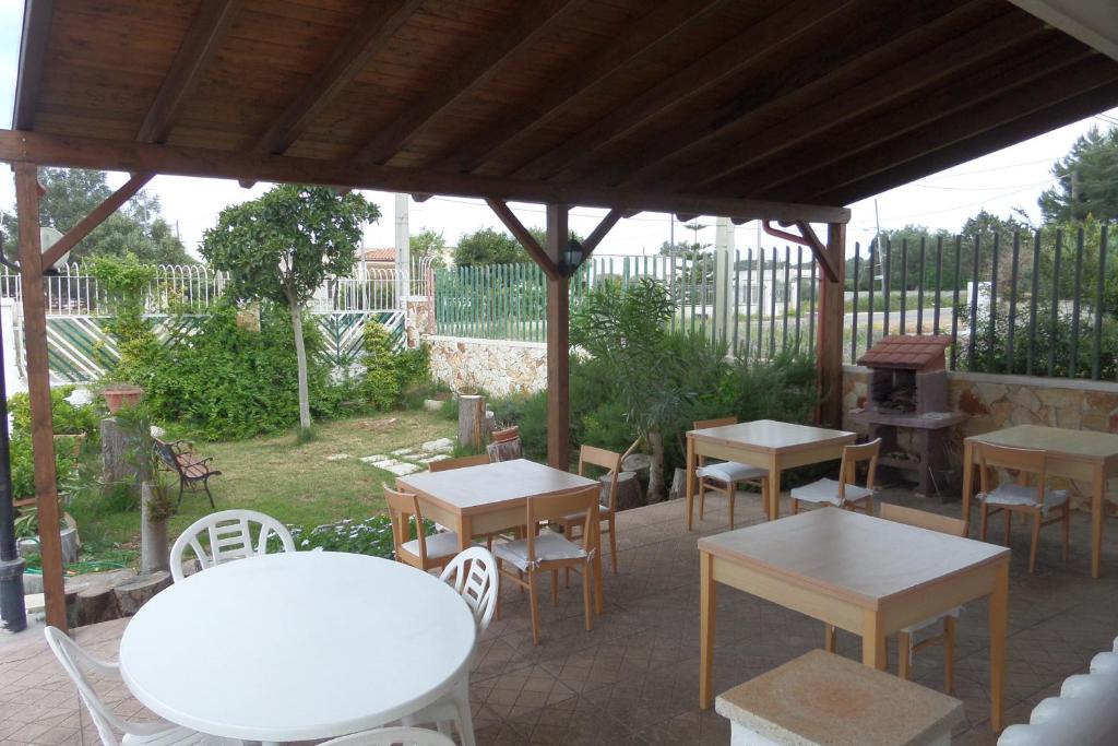 un gruppo di tavoli e sedie sotto un padiglione di Villa Itaca a Sant'Isidoro