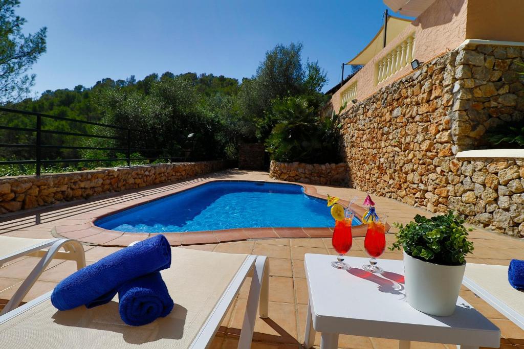 a swimming pool in a yard with two chairs and a table at Villa Magdalena in Calvià