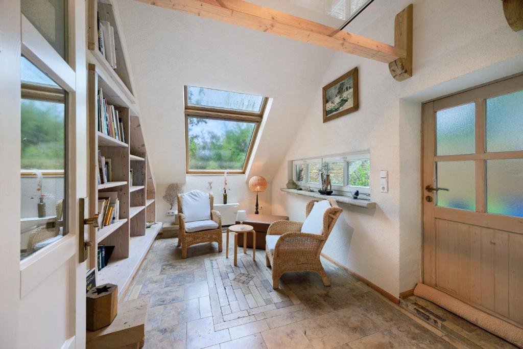 a room with a door and chairs and a table at Das Künstlerhaus - dein Sommerhaus in Köckern