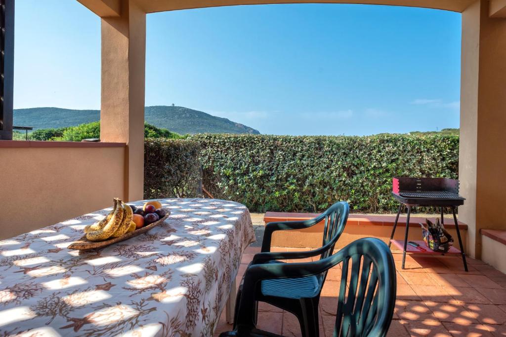 a table with a bowl of fruit and chairs on a patio at Pergola 706 in Stintino