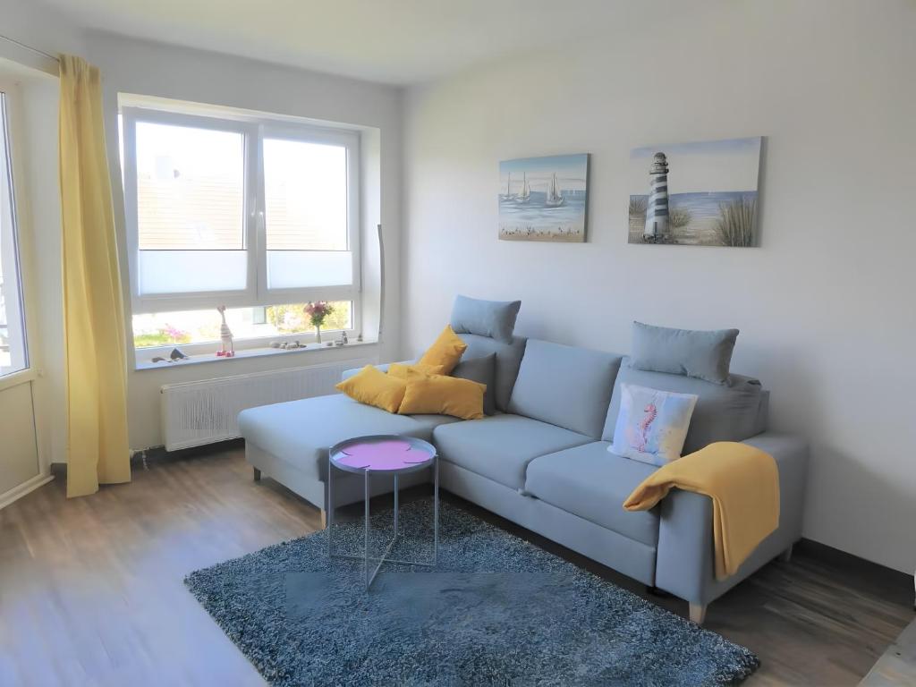 a living room with a couch and a table at Ferienwohnung Seepferdchen in Heiligenhafen