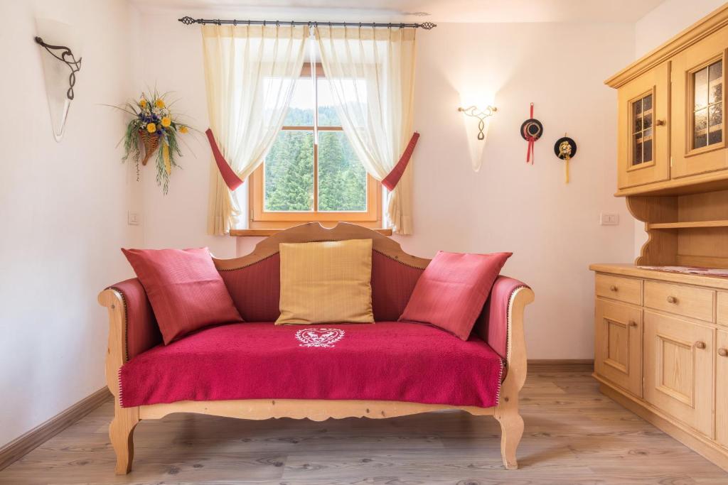 a red couch in a room with a window at Chalet Crepes De Sela in Canazei