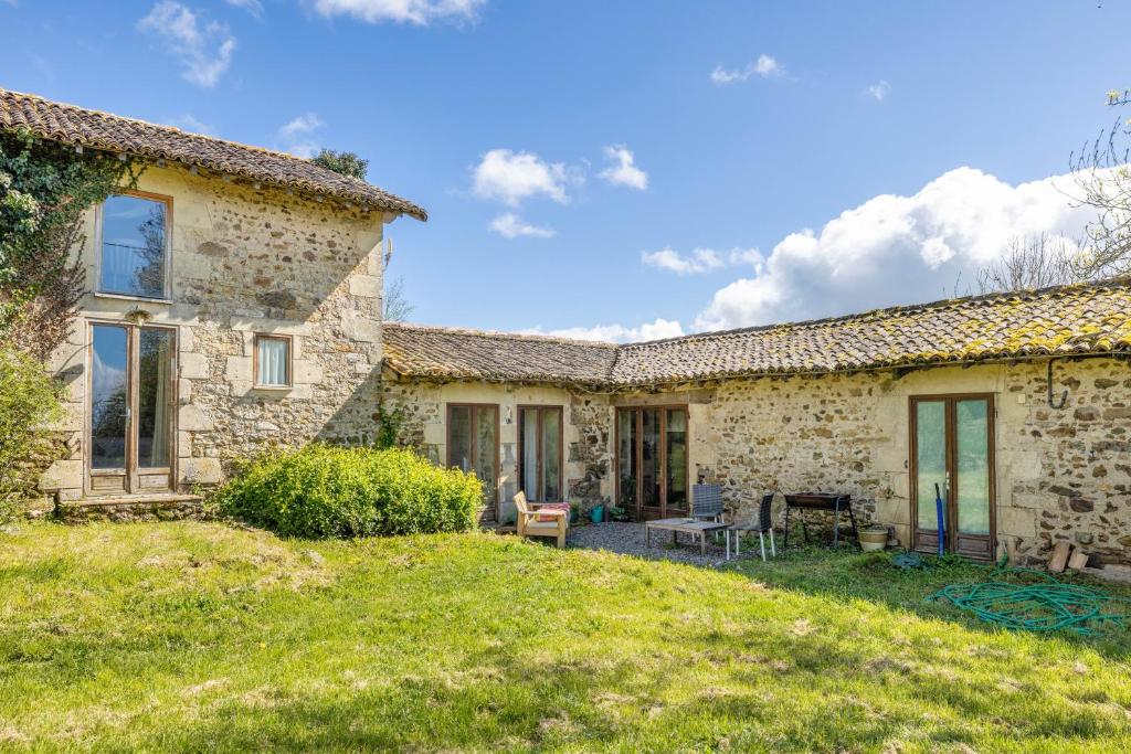 an exterior view of a stone house with a yard at Gîtes Bourdeverre in Sanxay