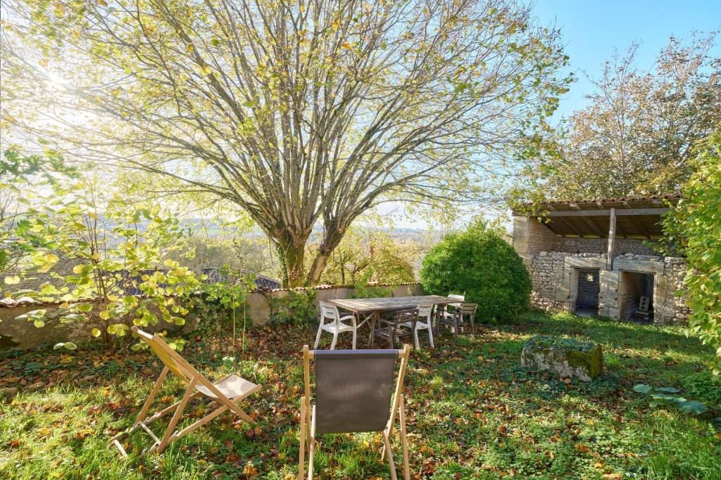 a table and chairs in the yard of a house at Gite La Ferme En Sud Charente in Montboyer