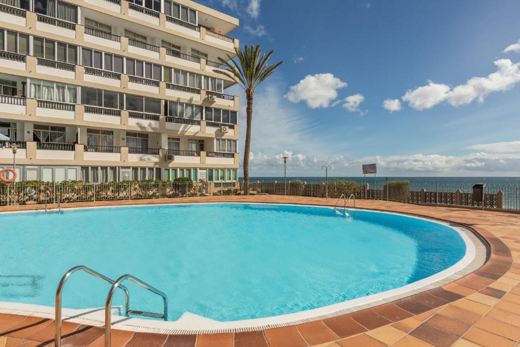 a large swimming pool in front of a hotel at Apartamento Soraya in San Bartolomé