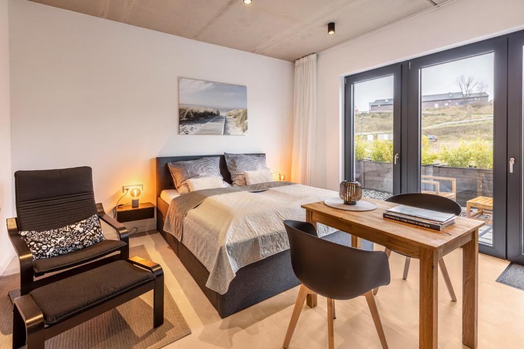 a bedroom with a bed and a desk and a chair at Apartment Schlossterrassen 4a in Pouch