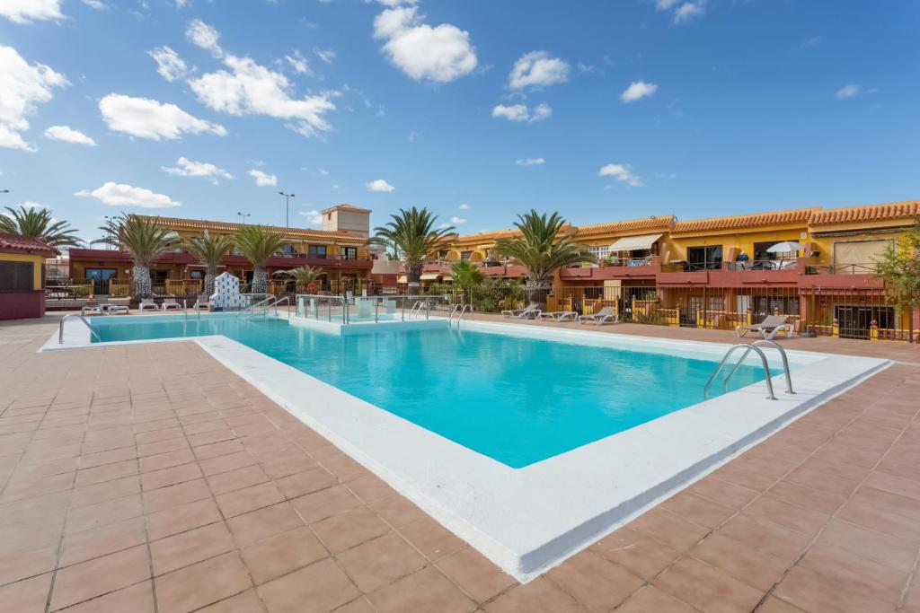 a pool at a resort with palm trees and buildings at Casa Lita in Antigua