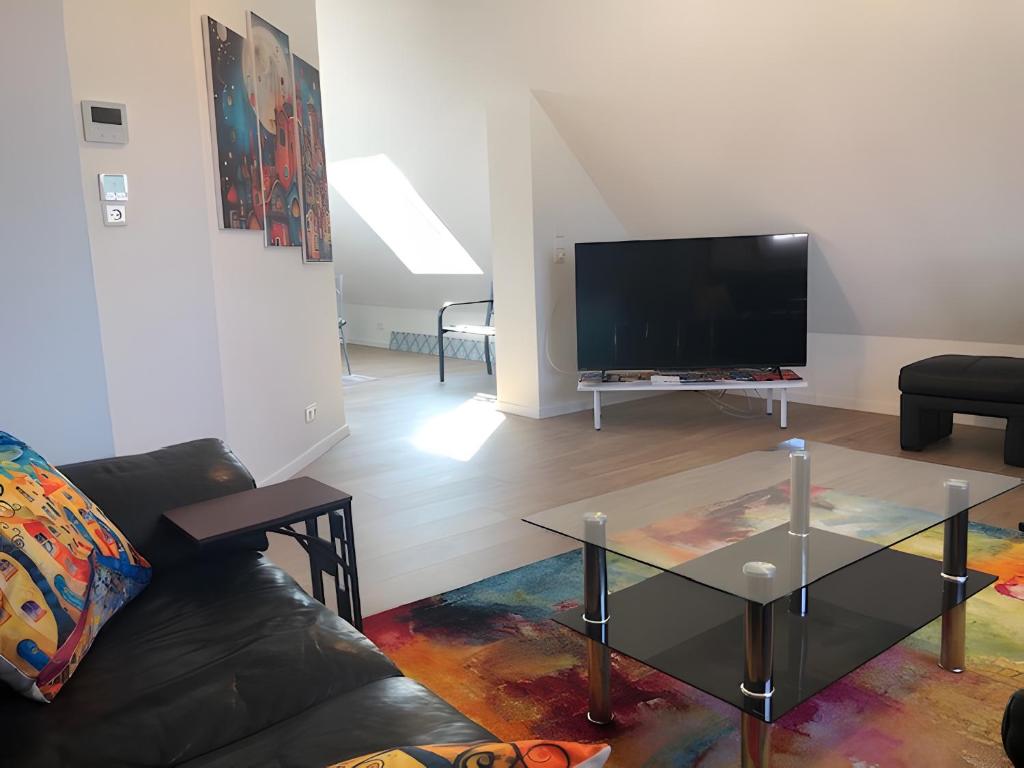 a living room with a black couch and a tv at Good Habits in Kleinengstingen