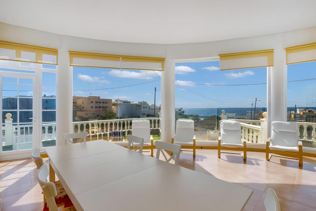 a white table and chairs in a room with windows at Casa del Pescador 2 in Santa Cruz de Tenerife