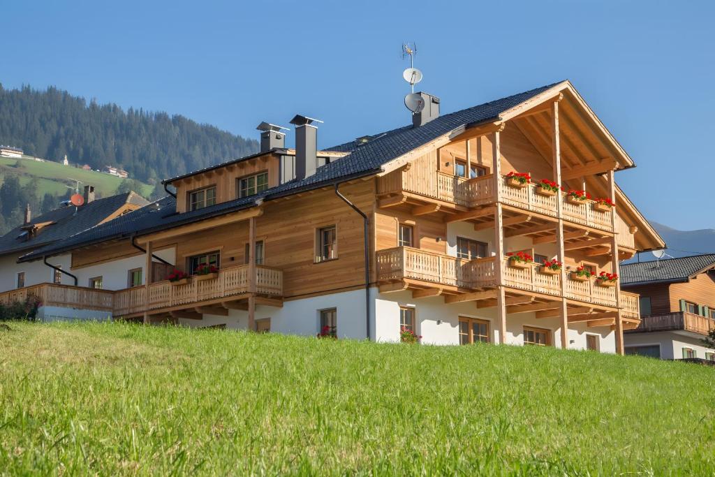 a large wooden building with balconies on a hill at Altmessnerhof in Dobbiaco