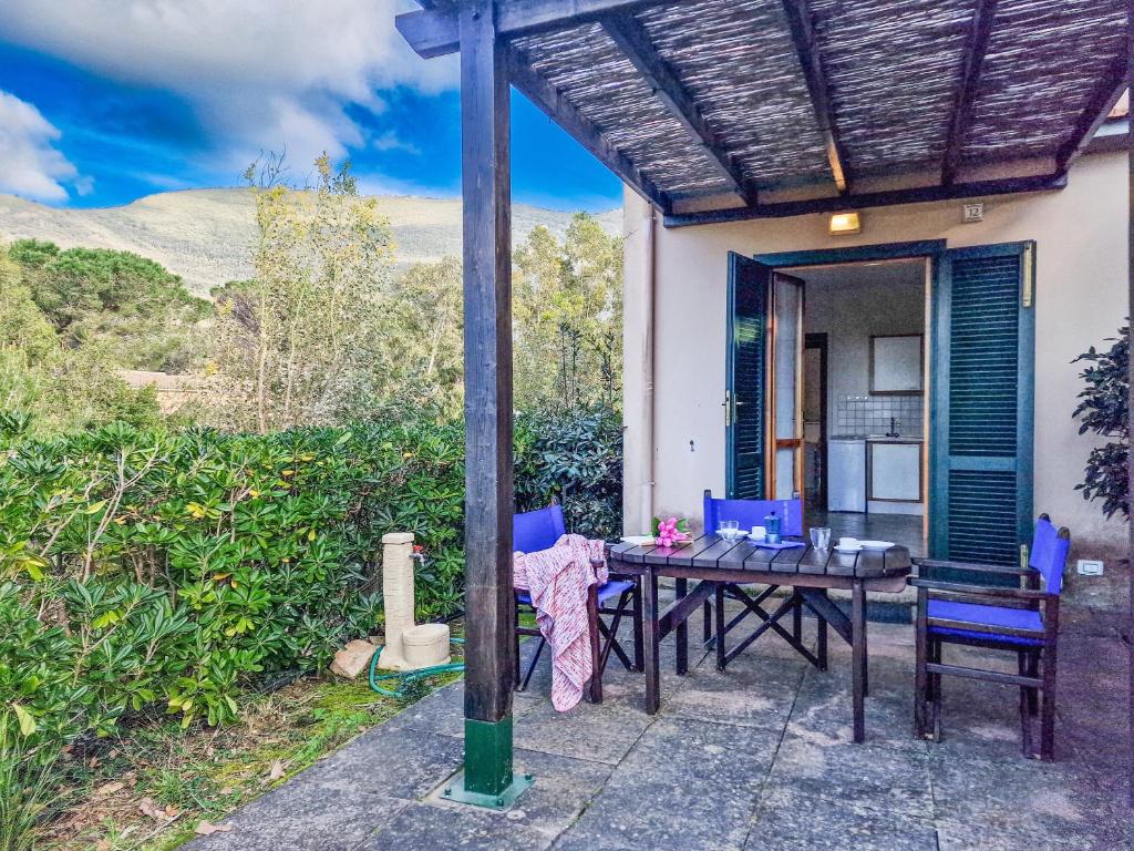 a patio with a table and chairs in front of a house at Altaluna Apartment with Pool in Nisporto