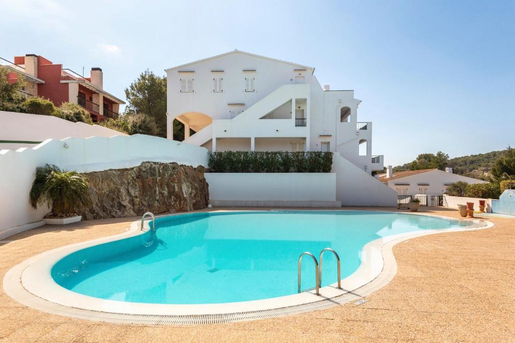 a swimming pool in front of a house at Apartamento Dos Geckos in Son Parc