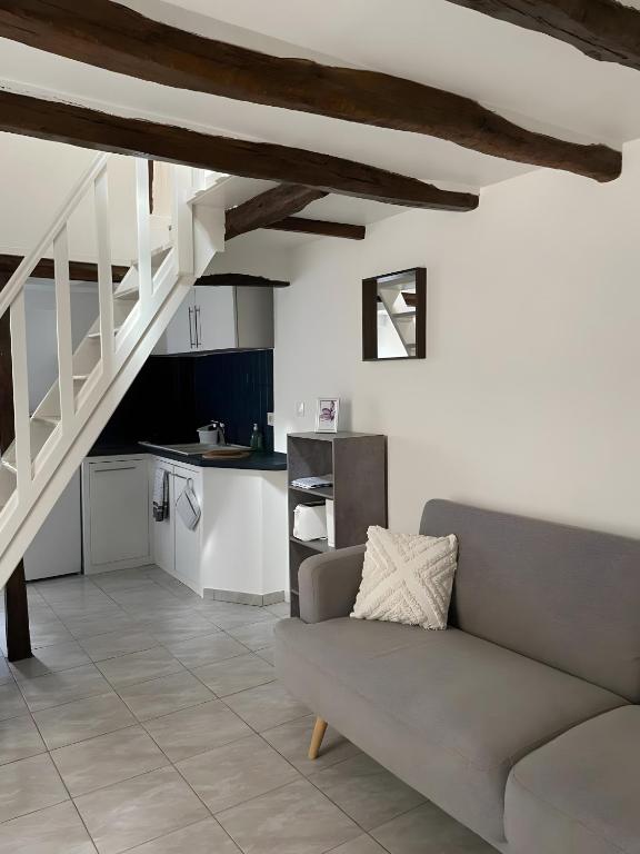 a living room with a couch and a kitchen at Logement Cosy centre Joigny C4 in Joigny