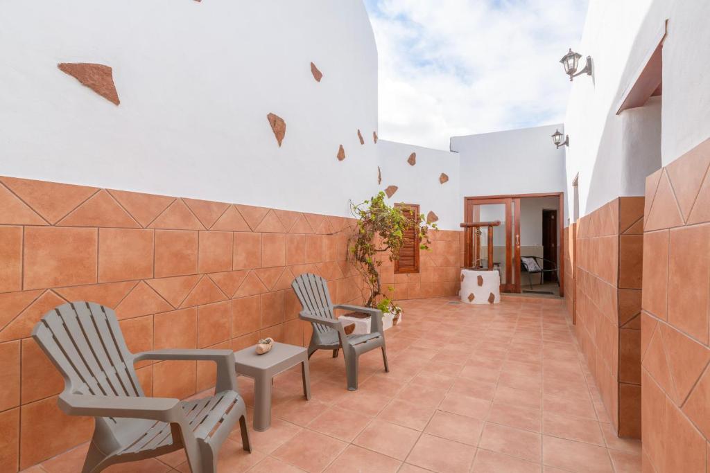 two chairs and a table in a room with a wall at Casa Abuela Nicolasa in Máguez