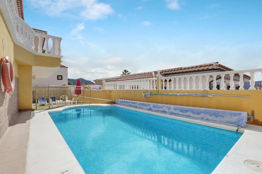 a pool in the backyard of a house with a building at Apartamento villasol in Arona